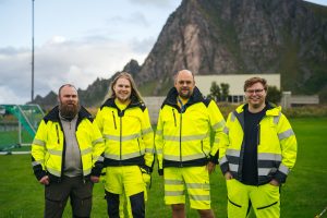 fire menn, synlighetstøy, på gresslette, foran fjell