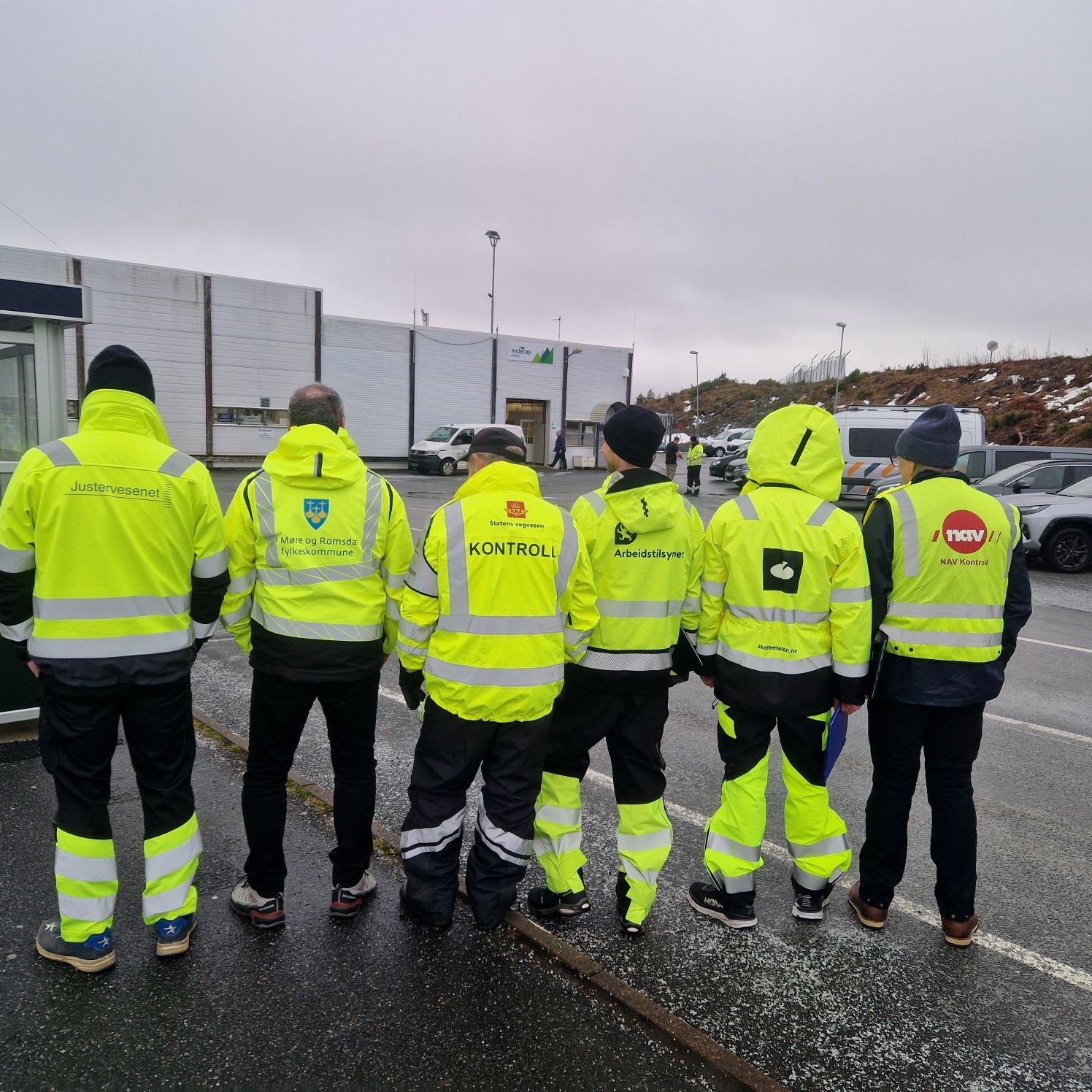 Personer i synlighetstøy med logoer