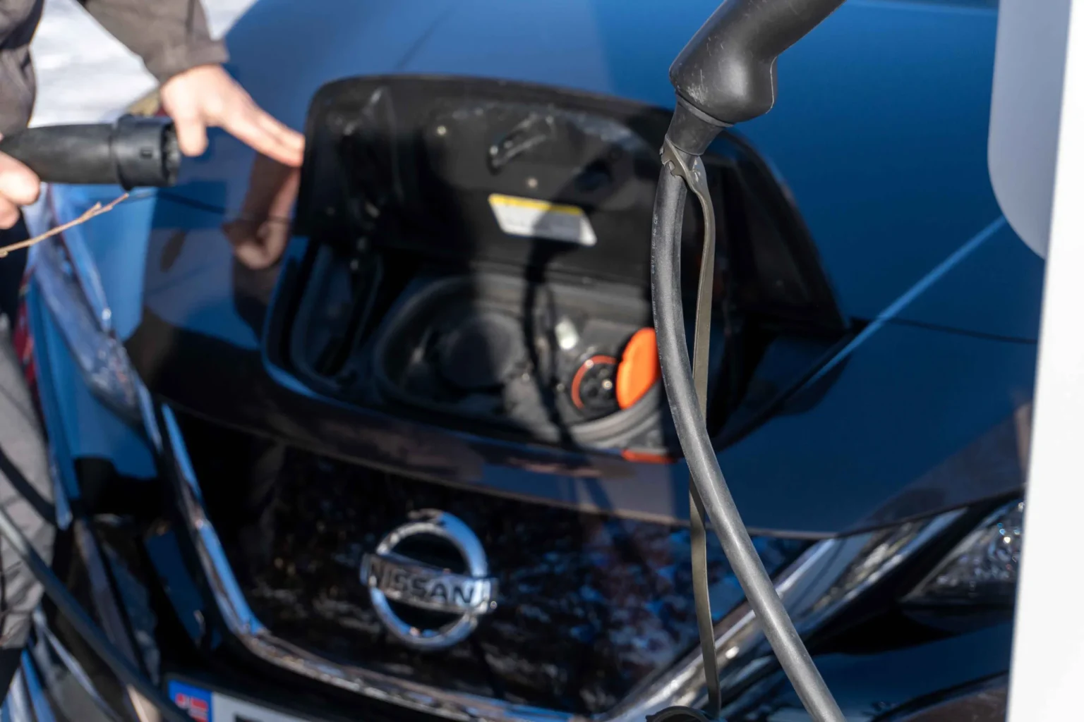 Bildet viser en el-bil som kobles til lader.