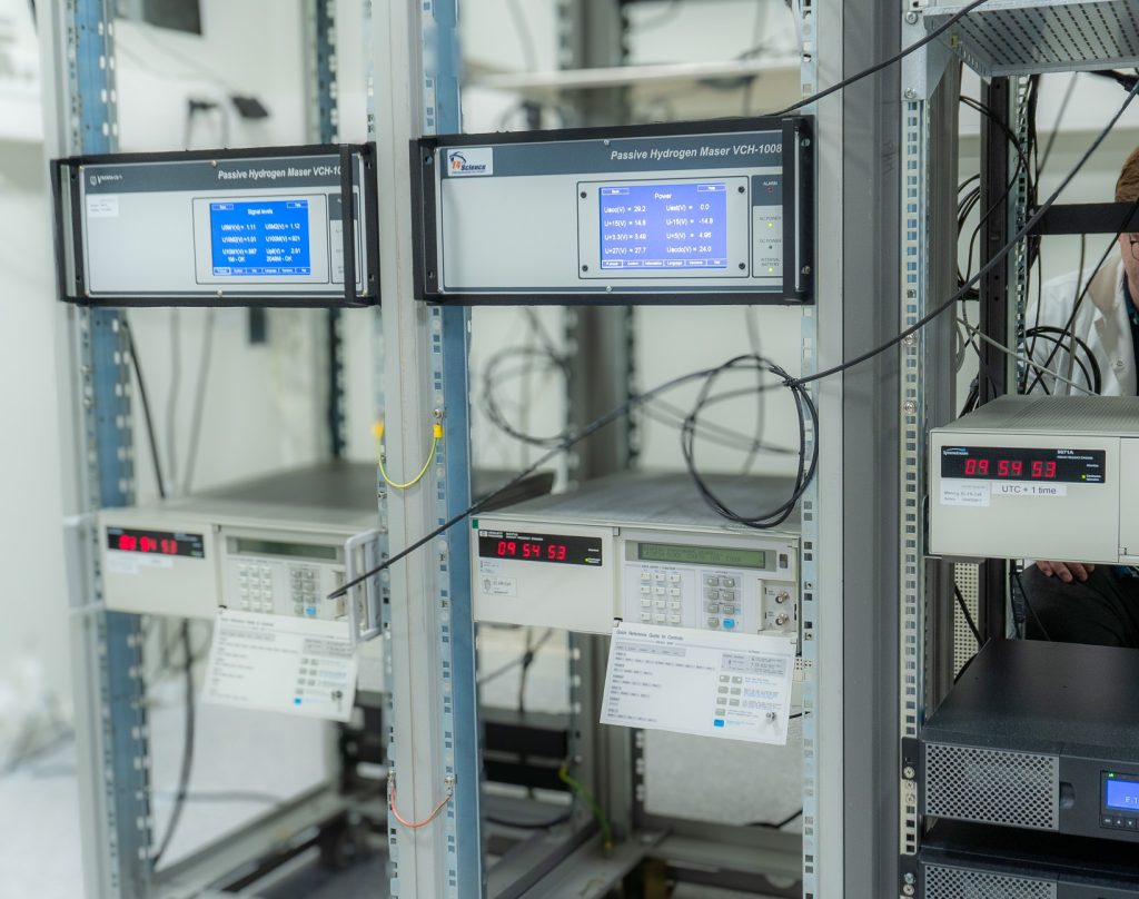 fem atomklokker i stativ på lab